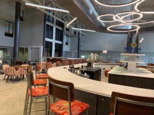 a large room with chairs and a bar with a counter at Holiday Inn Baton Rouge-South, an IHG Hotel in Baton Rouge