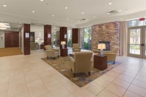 a lobby with chairs and tables and a fireplace at Holiday Inn Baton Rouge College Drive I-10, an IHG Hotel in Baton Rouge