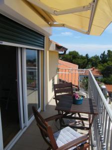 a balcony with a wooden table and chairs on a porch at Apartment Mamut in Premantura
