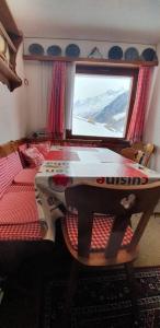 Una mesa en una habitación con cama y ventana en Hilburgs-Domizil, en Zermatt