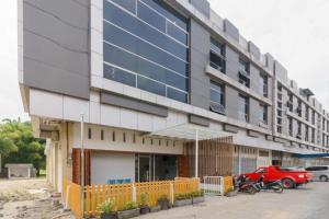 a building with a red car parked in front of it at RedDoorz @ Helvetia Medan 2 in Pulauberayan