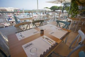 a restaurant with tables and chairs on a balcony at Pigna Felice Talamone in Talamone