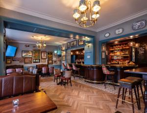 a restaurant with a bar and tables and chairs at Avalon House Hotel in Castlecomer