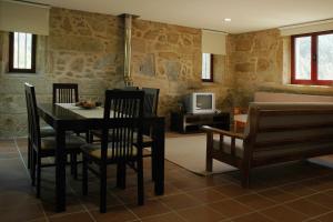 uma sala de jantar com mesa e cadeiras e uma TV em Hotel Rural Quinta de Novais em Arouca