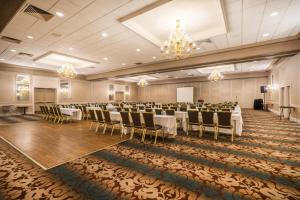 a banquet hall with tables and chairs in a room at enVision Hotel & Conference Center Mansfield-Foxboro in Mansfield