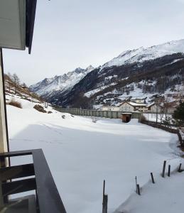 a snow covered field with a house and mountains at Hilburgs-Domizil in Zermatt