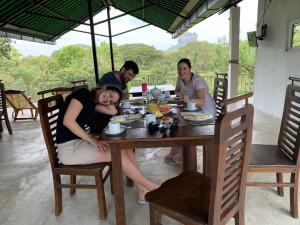 a group of people sitting around a wooden table at Sigiriya Rock Hide in Sigiriya