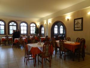 a dining room with tables and chairs and windows at Dom Pielgrzyma in Kalwaria Zebrzydowska