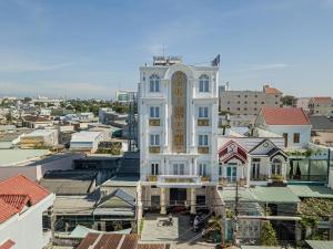 a white building with a clock tower in a city at Yurii Hotel in Phan Thiet