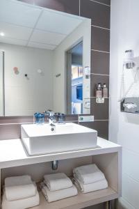 W łazience znajduje się umywalka, lustro i ręczniki. w obiekcie Hotel Kaijoo by HappyCulture w Strasburgu