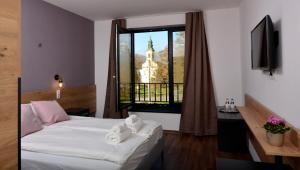 MartonvásárLudwig Hotel的一间带床和窗户的酒店房间