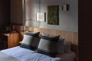 a bedroom with a bed with four pillows at Hôtel Restaurant Le Monêtier in Le Monêtier-les-Bains