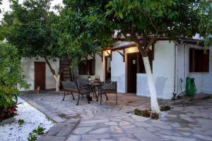 un patio con tavolo e sedie sotto un albero di Sweet Home a Volos