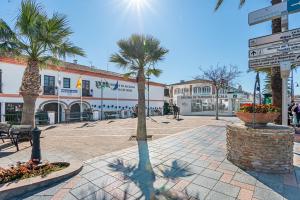 Una plaza con palmeras y un edificio. en Divina Home Apartments, en La Cala de Mijas