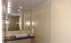 a bathroom with a sink and a mirror at Pride Ananya Resorts in Puri