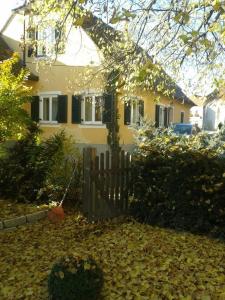 a house with a fence and leaves in front of it at Das Pernerhaus in Pöllau
