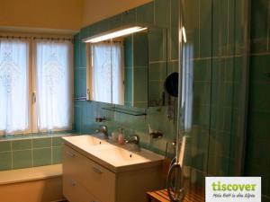 a green bathroom with a sink and a mirror at Das Pernerhaus in Pöllau