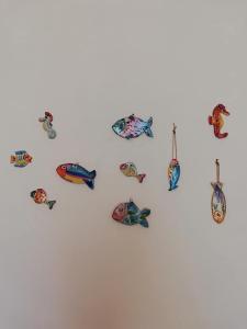 un gruppo di ornamenti per pesci appesi a una parete di Blue Sea Apartment a Torre Canne