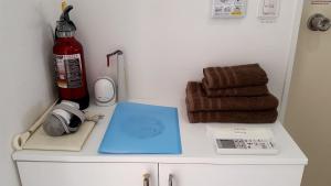 a counter with a phone and a thermometer and towels at Shima Stay holoholo in Zamami