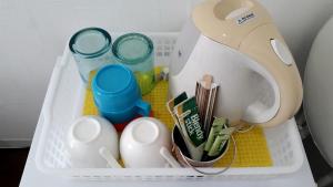 a plastic container with cups and a hair dryer at Shima Stay holoholo in Zamami
