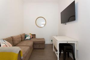 un soggiorno con divano e TV a schermo piatto di Quokka at White Gum Lodge a Fremantle