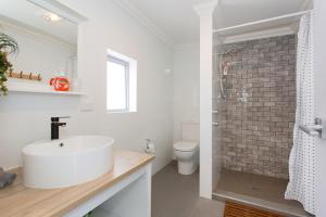 bagno con lavandino bianco e parete in mattoni di Quokka at White Gum Lodge a Fremantle Altre 15 foto