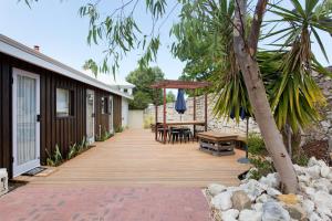una terrazza in legno con tavolo e ombrellone di Quokka at White Gum Lodge a Fremantle