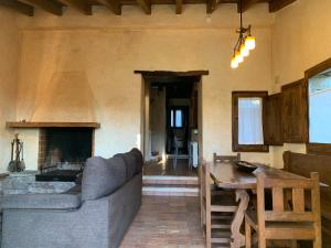 a living room with a couch and a fireplace at Can Vila in Tavertet