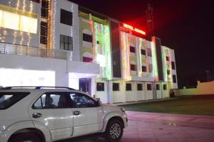 a car parked in front of a building at night at Hotel Adarsh in Aurangabad