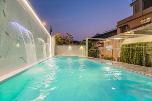 a swimming pool with a water fountain on a building at Marigold Sukhumvit - Free Shuttle to BTS Bearing Station in Bangkok