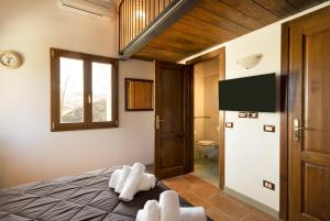 a bedroom with a bed and a television and a bathroom at Villa Viktoria & Andras in Tredozio