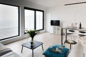- un salon avec un canapé et une table dans l'établissement Unieke Penthouse bij Brugge, à Blankenberge