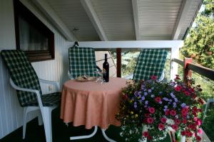 uma mesa com uma garrafa de vinho e flores num alpendre em Ferienwohungen Ingrid Gevers em Schneverdingen