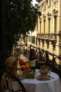 una mesa en un balcón con una mesa con fruta. en Residenza Borsari, en Verona