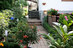 um jardim com flores e plantas em frente a uma casa em Ferienwohungen Ingrid Gevers em Schneverdingen