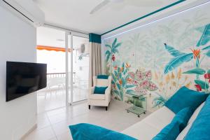 a living room with a couch and a wall mural at First line sea, luxury penthouse, sea and sunset view Vivenda Vacational Guayero 618 in Los Cristianos