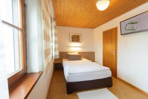 キルヒハイム・アム・リースにあるLandhotel Oßwaldのベッドと窓が備わる小さな客室です。