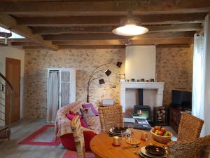 Roussines的住宿－La maison triangulaire，客厅配有桌子和壁炉