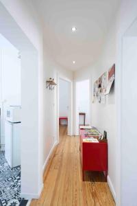 ein Wohnzimmer mit weißen Wänden und einem roten Tisch in der Unterkunft Rock in Share - Le Saint-Pierre in Metz