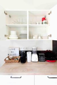 a kitchen with white cabinets and a counter top with dishes at Rock in Share - Le Saint-Pierre in Metz