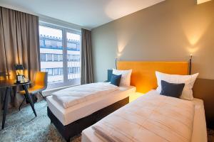 Postel nebo postele na pokoji v ubytování LOGINN Hotel Leipzig