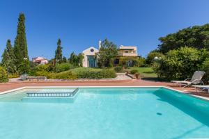 a swimming pool in front of a house at Ellie Villa in Tersanas