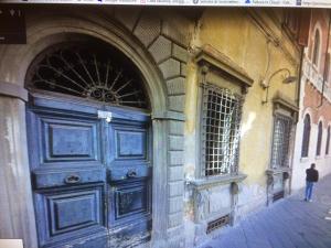a blue door on the side of a building at Torre Guinigi Luxury Loft nel centro storico di Lucca in Lucca