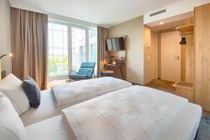 Postel nebo postele na pokoji v ubytování LOGINN Hotel Leipzig