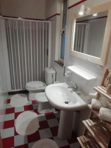 y baño con lavabo blanco y aseo. en Villa Davima, en Marzamemi