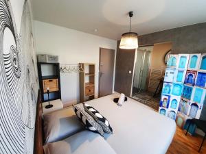 a bedroom with a large white bed with pillows at La Maison Bisca in Biscarrosse-Plage