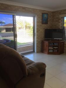 a living room with a couch and a television at Holiday on Hillcrest in Scarness