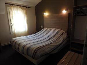 ein großes Bett in einem Schlafzimmer mit Fenster in der Unterkunft Logis Hôtel Restaurant Les Cévennes in Saint-Cirgues-en-Montagne