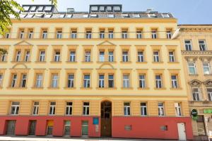 um edifício amarelo com portas vermelhas numa rua em Penthouse near Schoenbrunn with large terrace! N43 em Viena