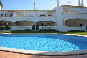 a villa with a swimming pool in front of a house at Paradise Beach Villa in Albufeira